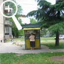 Photo 1: A woman stands in front of a yellow kiosk.
