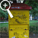 Photo 3: Front view of yellow kiosk covered in graffiti.