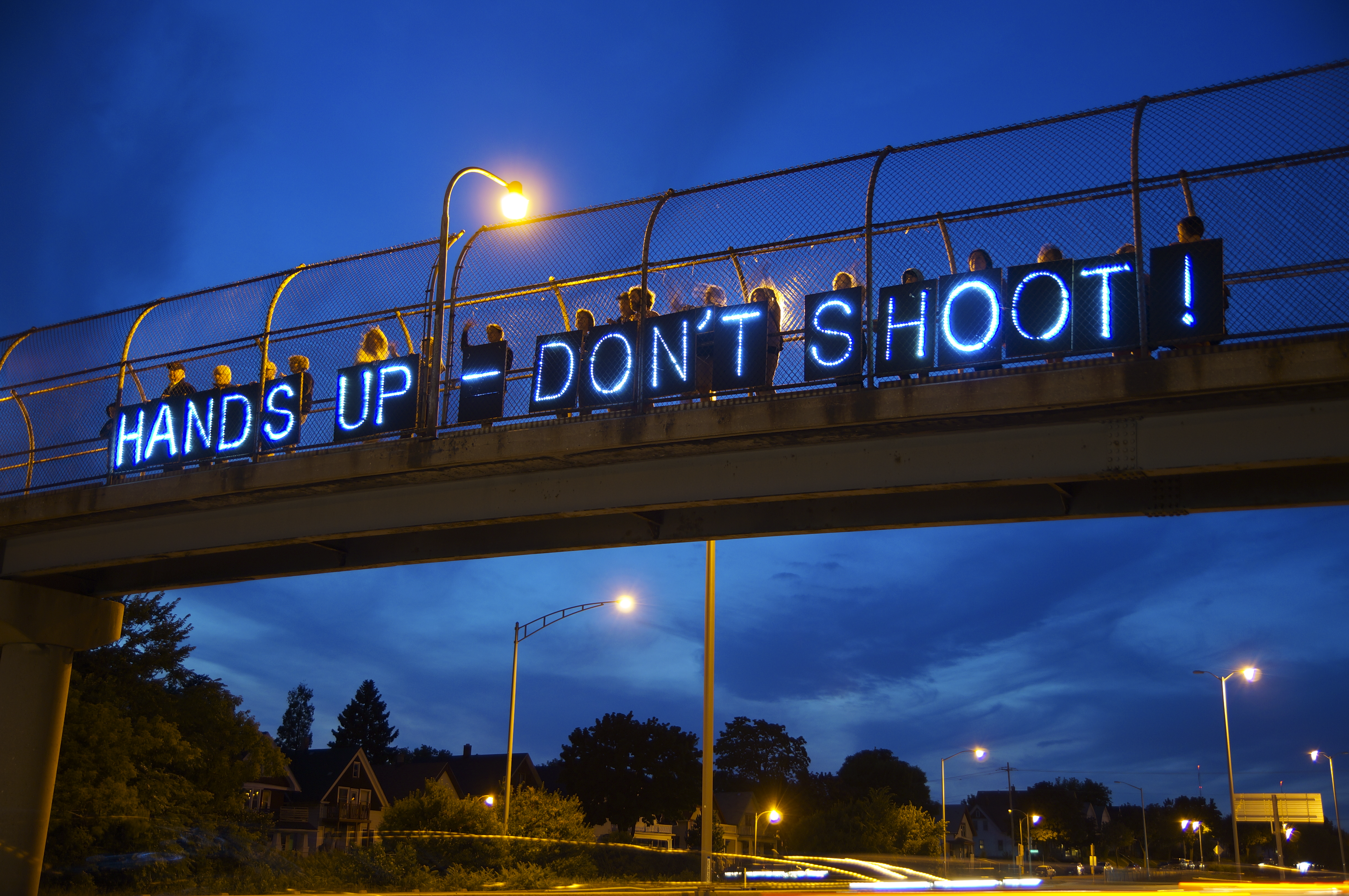 Photograph of "Hands up, Don't Shoot" sign on bridge