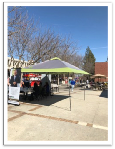 People and tables set up in the free speech area.