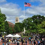 University of Michigan Diag during Festifall in September 2010. Image shows a large crowd gathered and an American flag in the center of the photo.