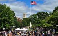 University of Michigan Diag during Festifall in September 2010. Image shows a large crowd gathered and an American flag in the center of the photo.